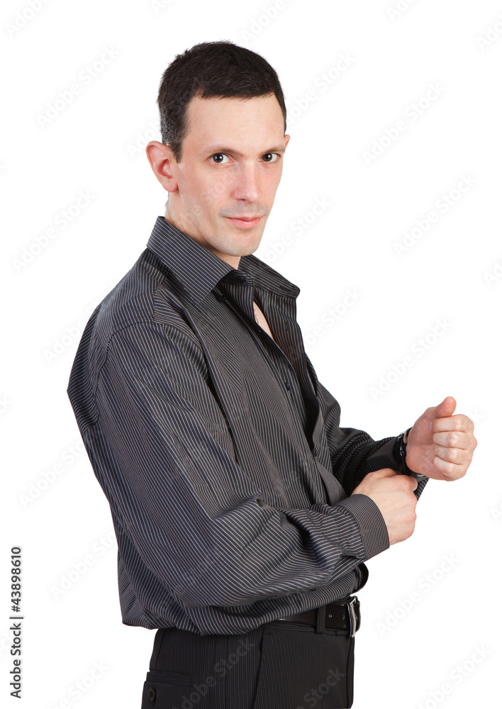 Young man buttoning-up a sleeve of his black shirt Young man buttoning-up a sleeve of his black shirt