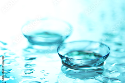 contact lens with drops on blue background