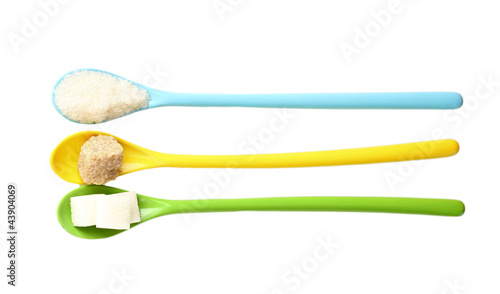 Bright colorful spoons with different types of sugar isolated