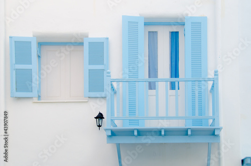 Beautiful blue windows Greek Style on white wall © happysunstock