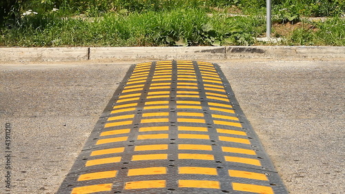 Speed bump on a road when a car is passing photo