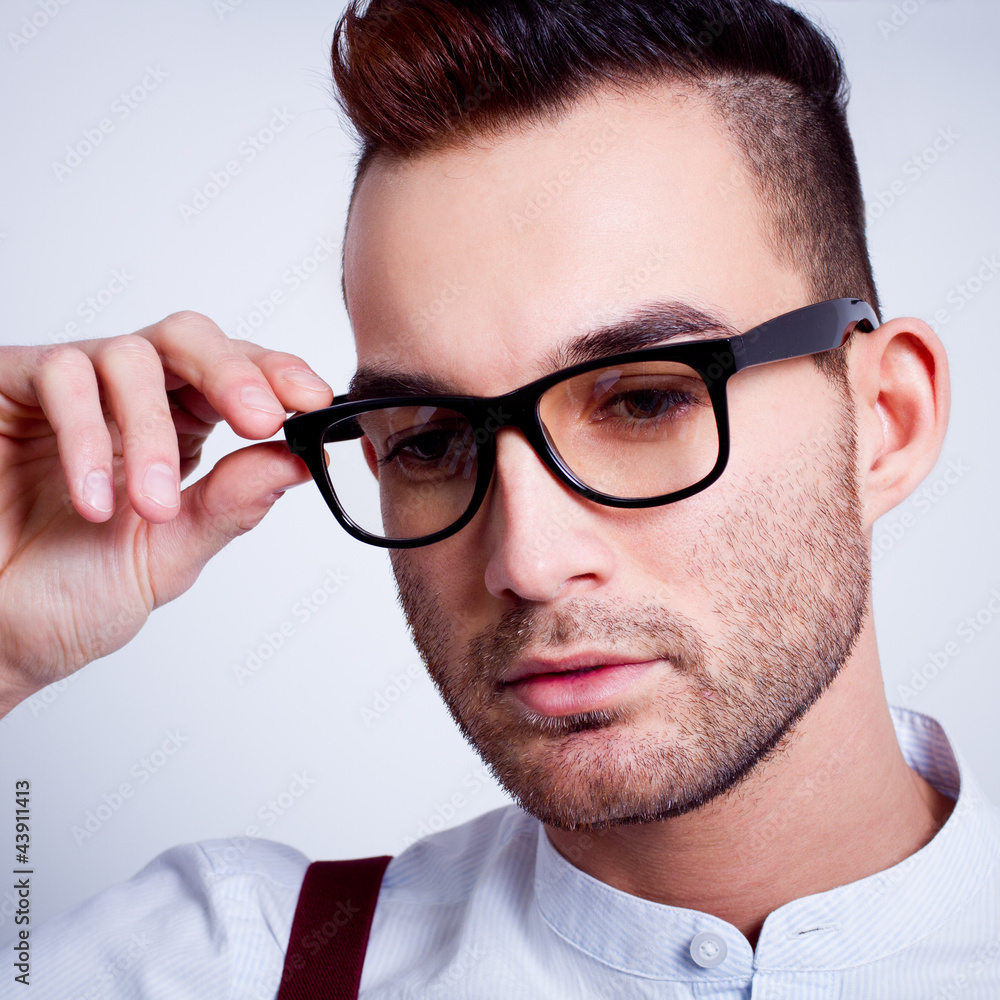 handsome young man holding glasses against white background handsome young man holding glasses against white background