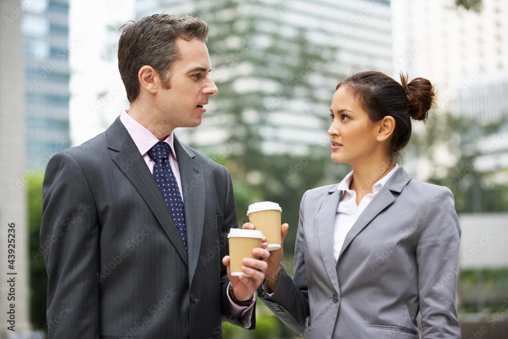 Businessman And Businesswoman Chatting In Street Holding Coffee Businessman And Businesswoman Chatting In Street Holding Coffee