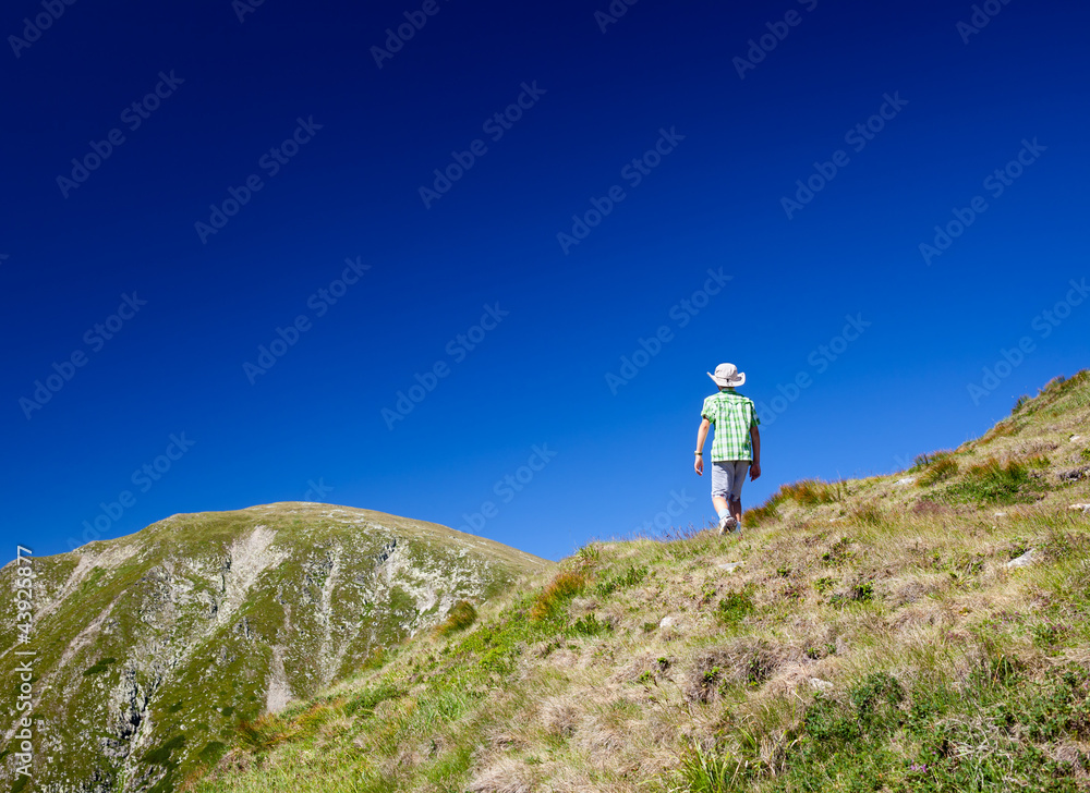 Boy hiking into the mountains