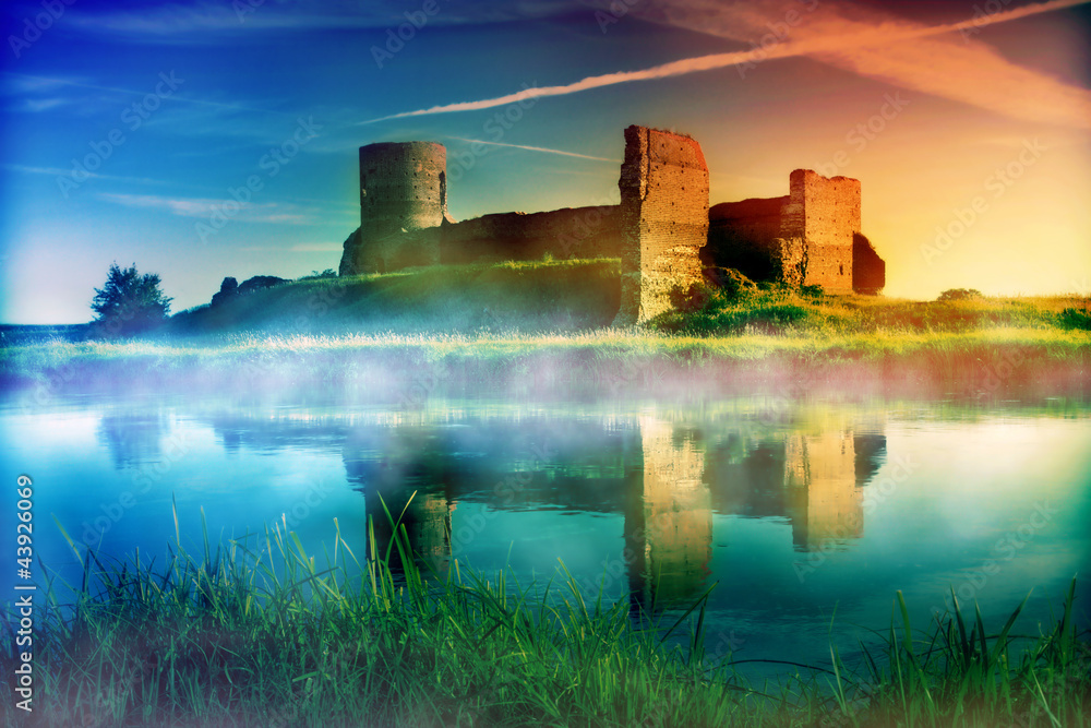 Old castle ruins at magical sunset at the river