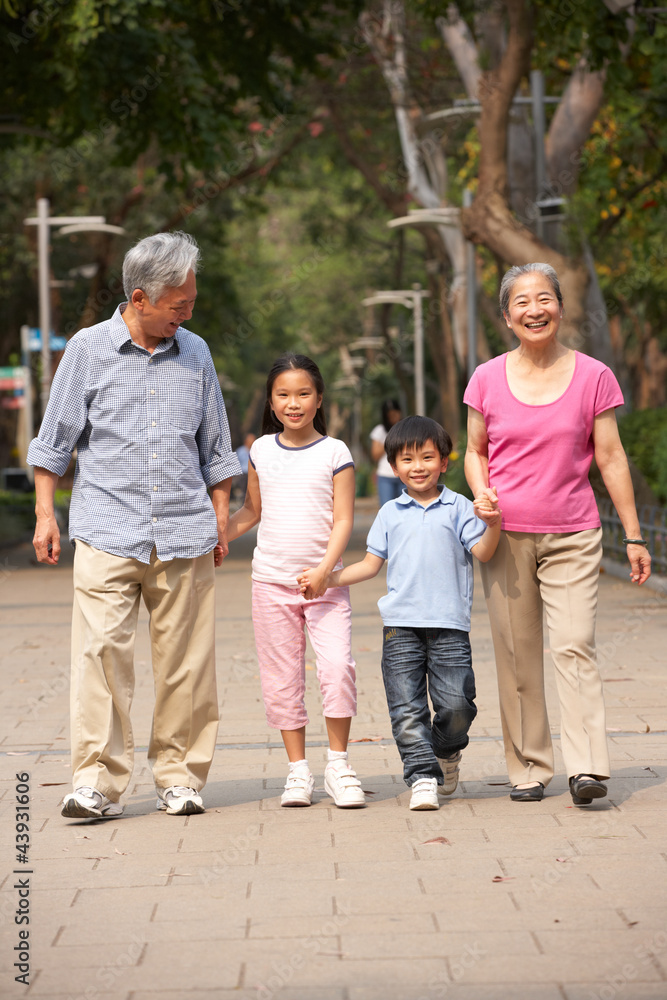 Chinese Grandparents Walking Through Park With Grandchildren Chinese Grandparents Walking Through Park With Grandchildren