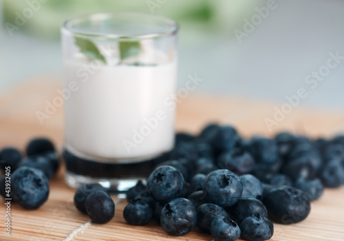 Obraz na płótnie Blueberry and a cup of yogurt decorated with leaves w salonie