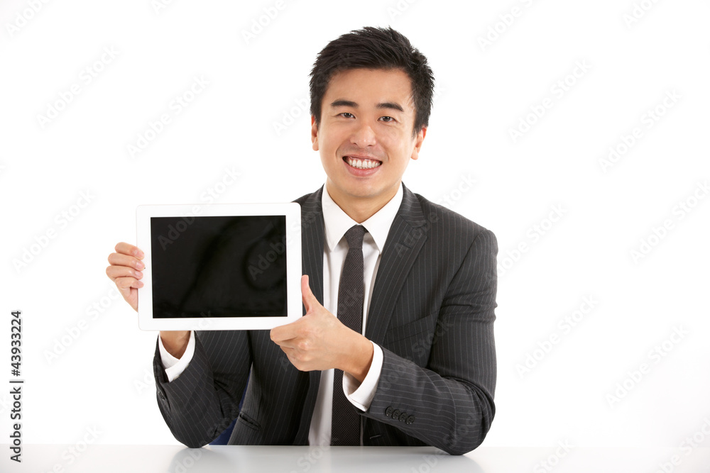 Studio Shot Of Chinese Businessman Working On Tablet Computer Studio Shot Of Chinese Businessman Working On Tablet Computer