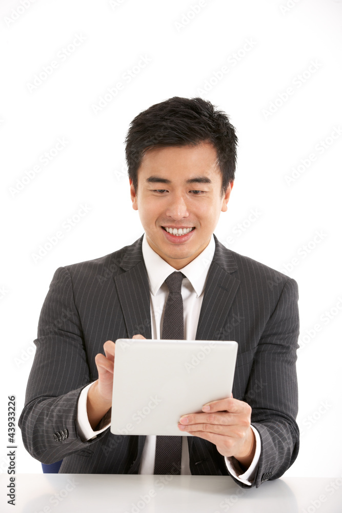 Studio Shot Of Chinese Businessman Working On Tablet Computer Studio Shot Of Chinese Businessman Working On Tablet Computer