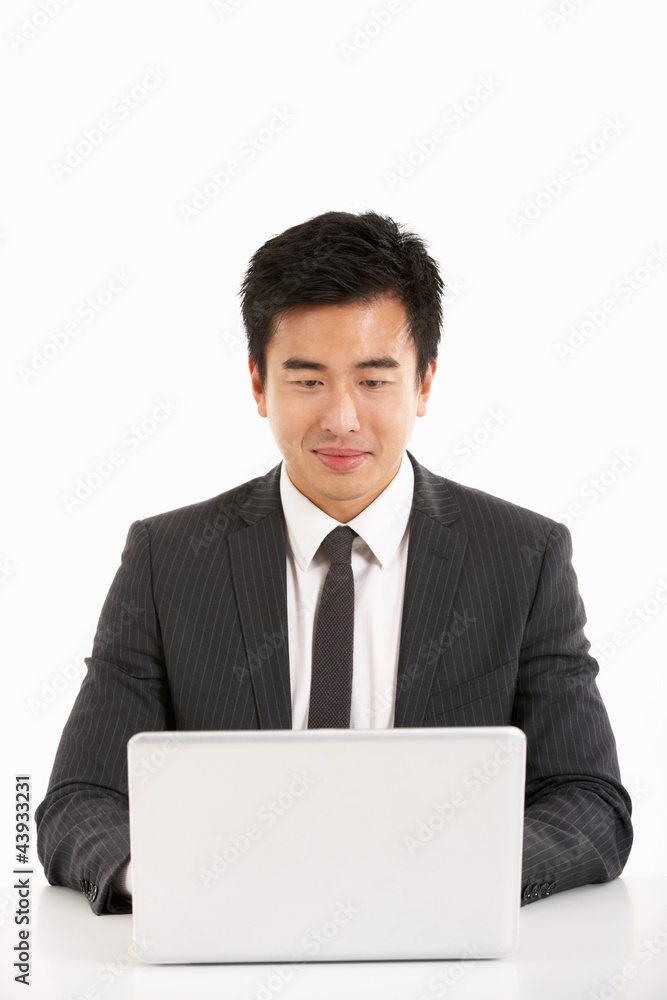 Studio Shot Of Chinese Businessman Working On Laptop Studio Shot Of Chinese Businessman Working On Laptop