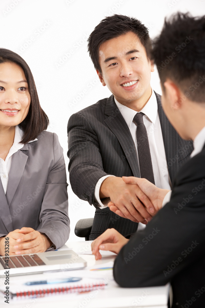 Two Chinese Businessmen Shaking Hands During Meeting Two Chinese Businessmen Shaking Hands During Meeting
