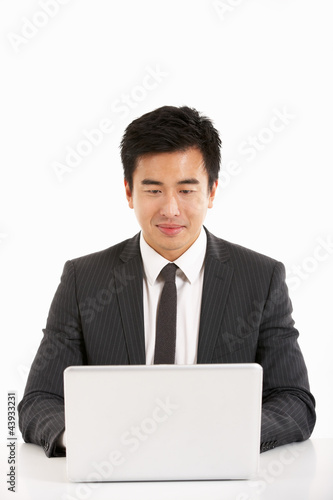 Studio Shot Of Chinese Businessman Working On Laptop