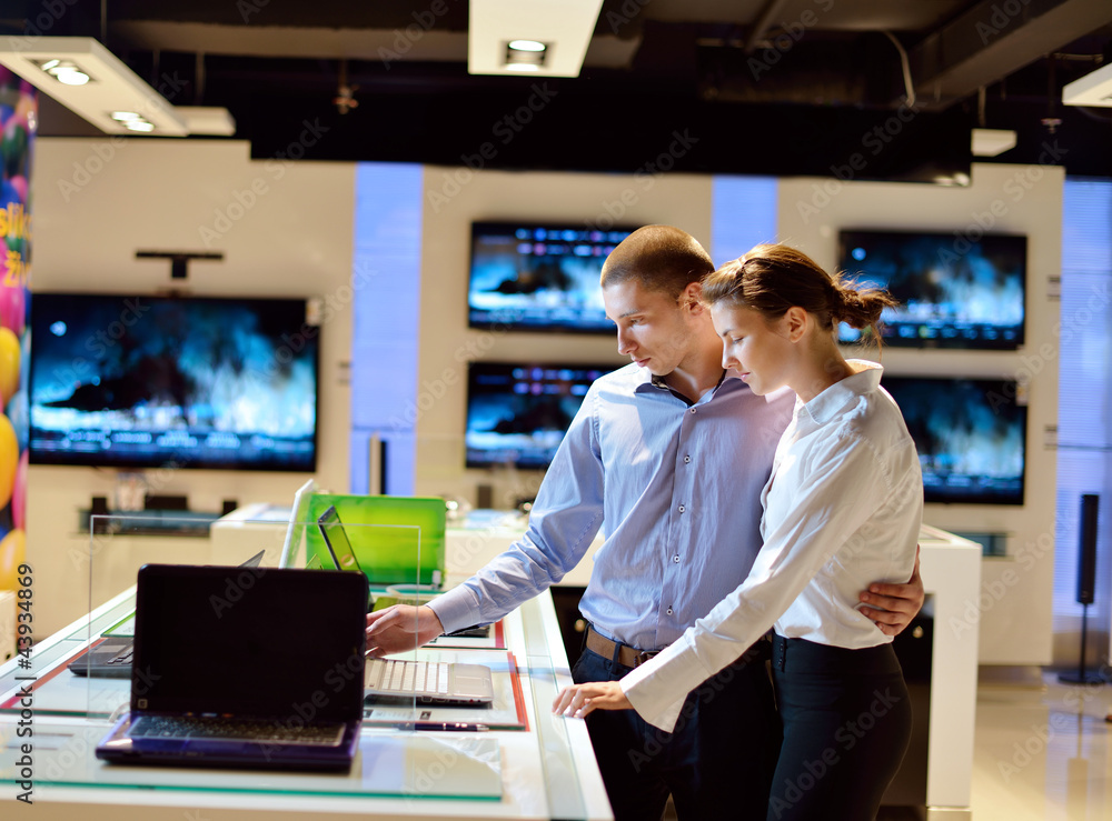 Young couple in consumer electronics store Young couple in consumer electronics store