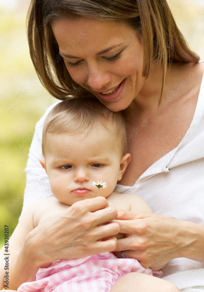 Mother Sitting With Baby Girl In Field Of Summer Flowers Mother Sitting With Baby Girl In Field Of Summer Flowers