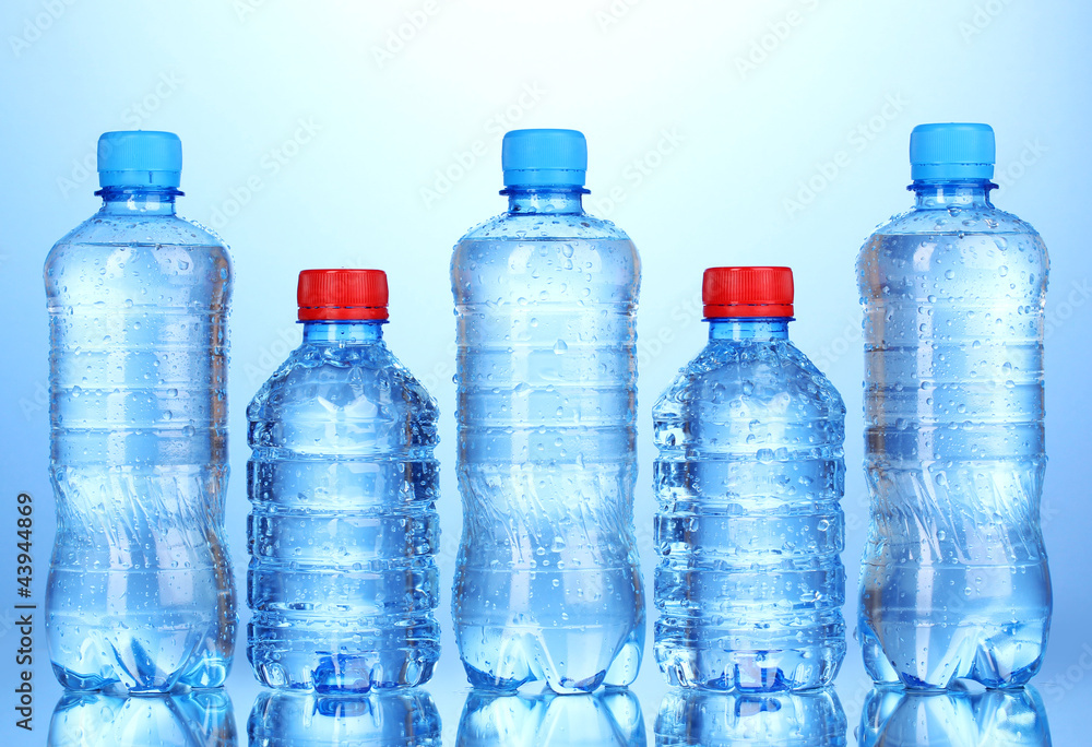 plastic bottles of water on blue background