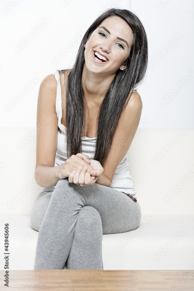 Young woman sat on white sofa Young woman sat on white sofa