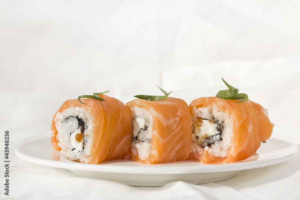 3 Philadelphia rolls on white plate with cloth linen background 3 Philadelphia rolls on white plate with cloth linen background