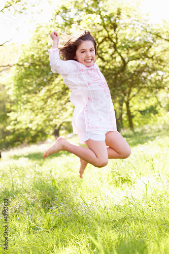 Young Girl Jumping In Summer Field