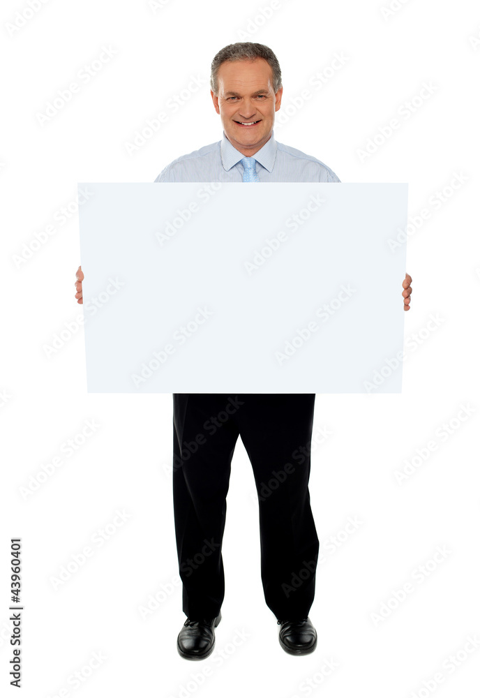 Confident businessman holding blank billboard Confident businessman holding blank billboard
