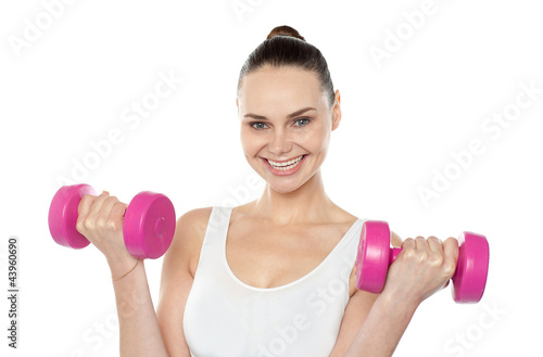 Attractive athlete exercising with dumbbells