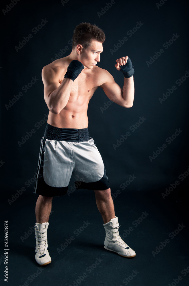 Sportsman boxer intense portrait in studio against black backgro