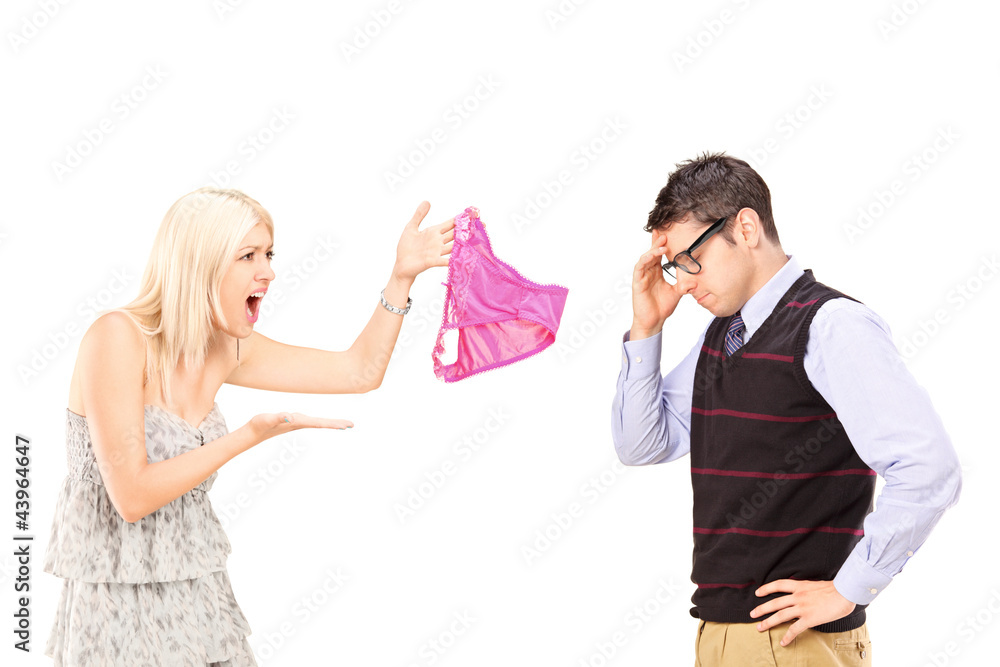 Angry girlfriend shouting at her boyfriend and holding knickers Angry girlfriend shouting at her boyfriend and holding knickers