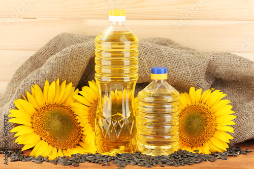 sunflower oil and sunflower on wood background