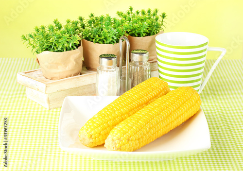 boiled corn and flowers on a green background