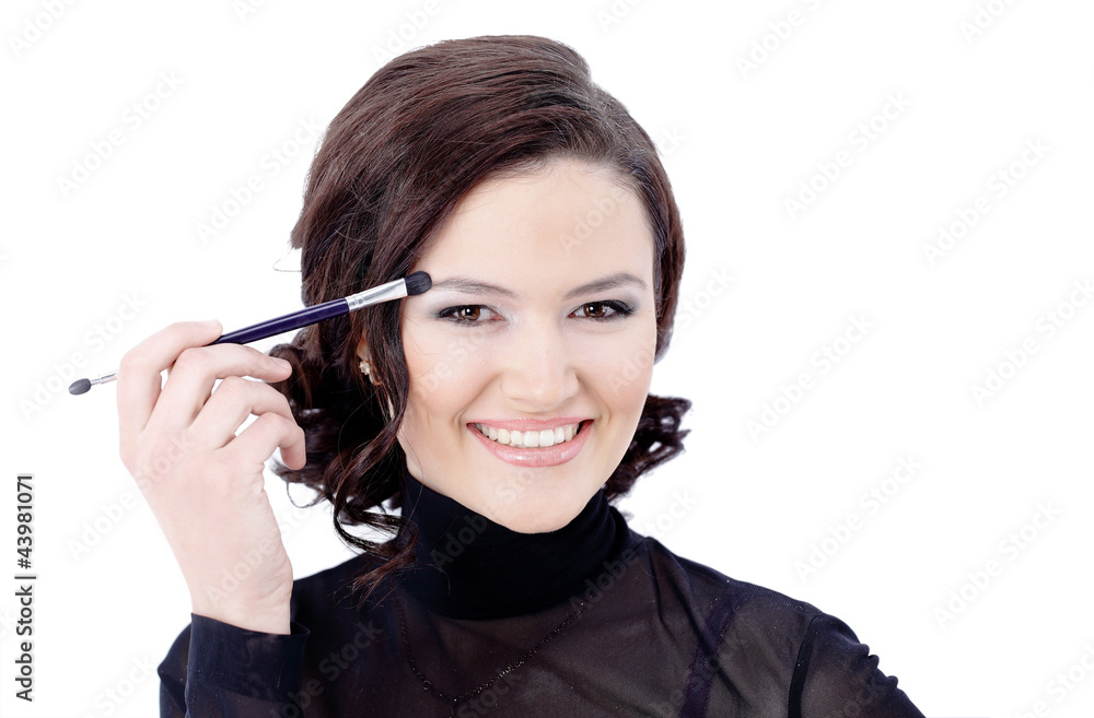 Obraz premium Beautiful woman with makeup brush near her face