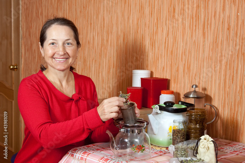 Mature woman brews herbs photo