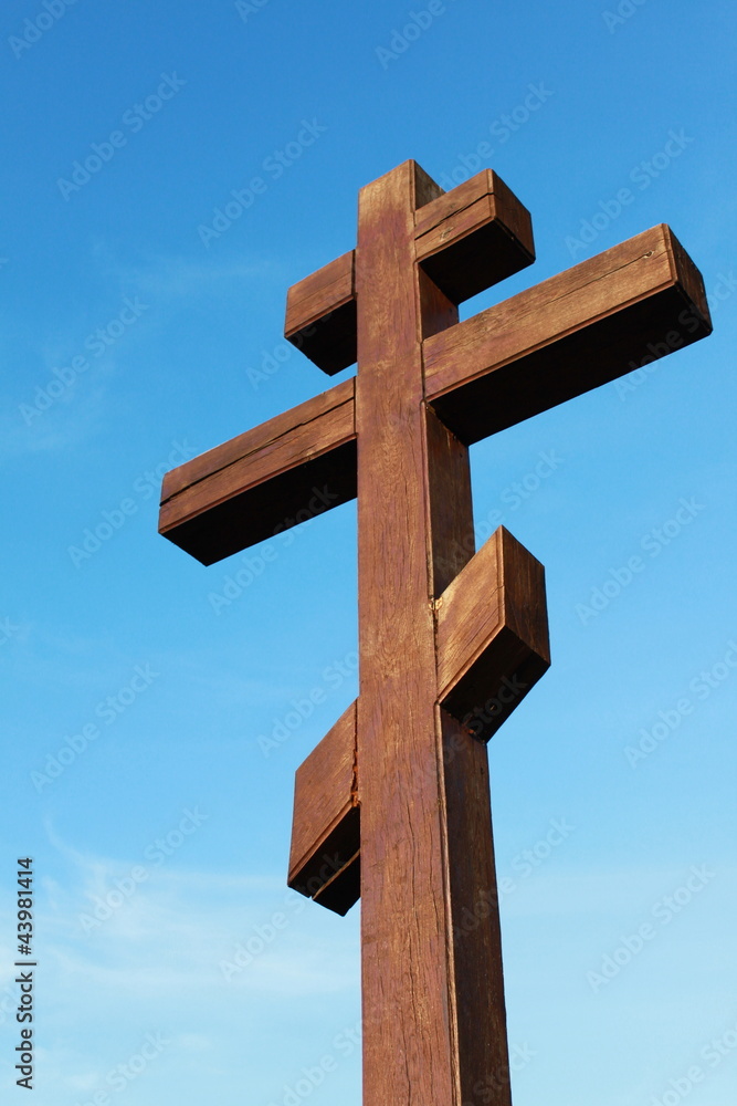 The wooden cross on a blue sky background
