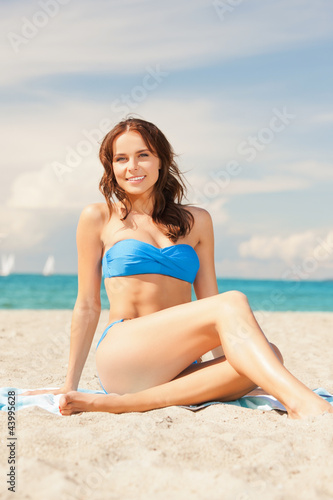 happy smiling woman sitting on a towel © Syda Productions