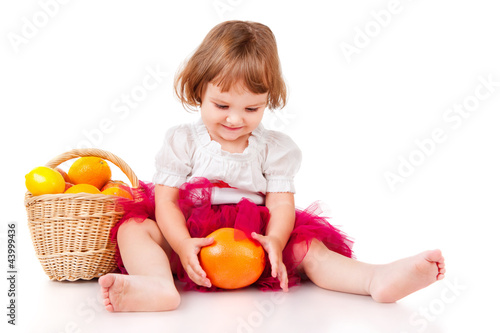 Little girl with a basket of oranges