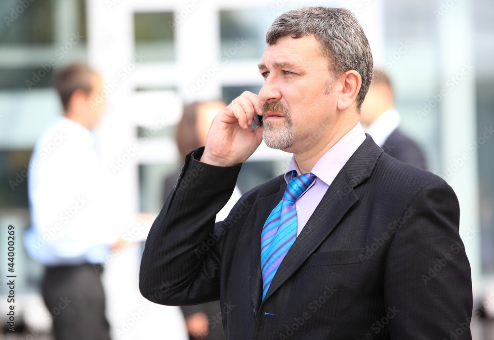 A handsome business man on phone at office building A handsome business man on phone at office building