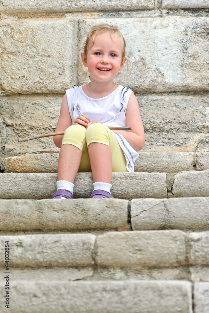 Cute little girl sitting on the stairs