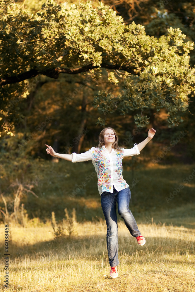 Young pretty woman jumping in the autumn park