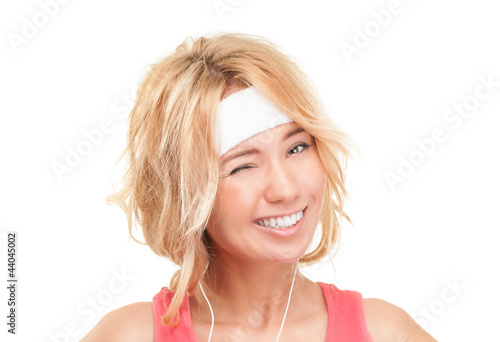 Young sporty woman winking on white background.