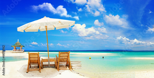 beautiful tropical sandy beach with umbrella and beach chair