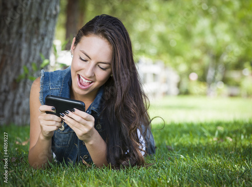 Mixed Race Young Female Texting on Cell Phone Outside