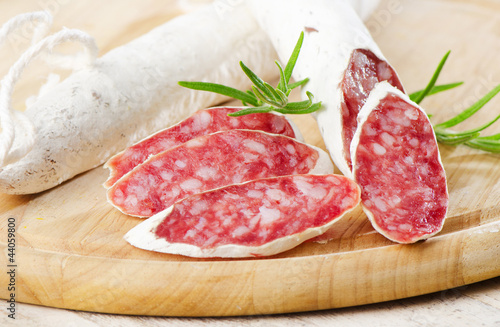 Salami sliced on wooden table