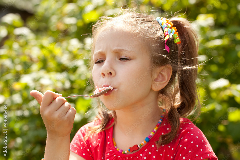 Girl in a red blouse eating ice cream Girl in a red blouse eating ice cream