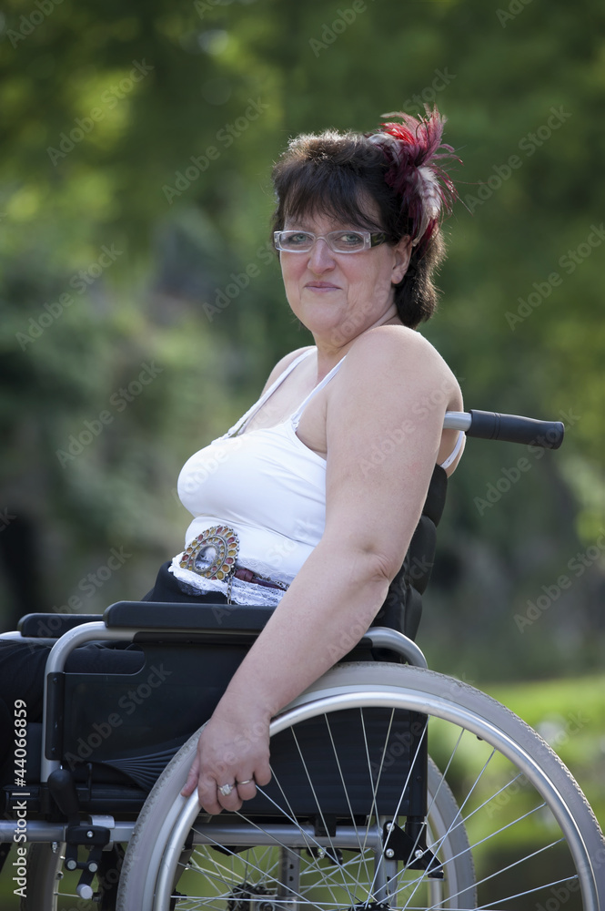 Obraz premium adult woman in wheelchair outdoors in the park