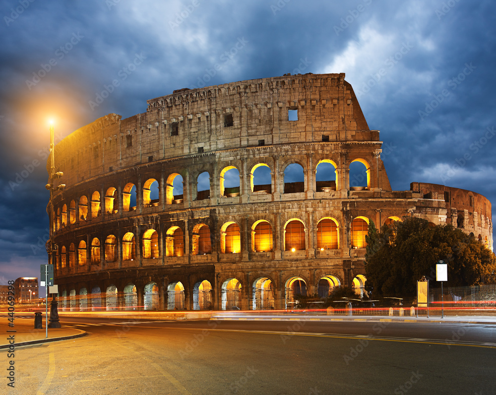 Colosseum and traffic lights at night in Rome, Italy