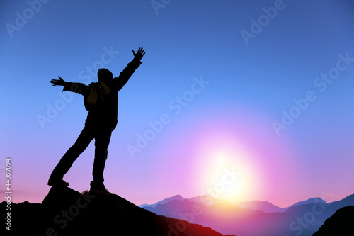 young man standing on the top of mountain