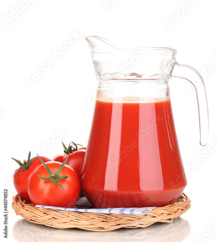 Tomato juice in pitcher on wicker mat isolated on white © Africa Studio