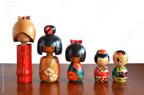 japanese wood dolls on wood table with white background