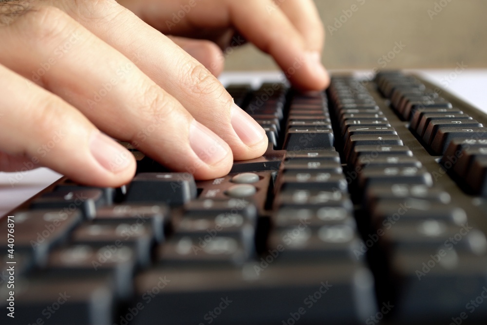man's hand on computer keyboard man's hand on computer keyboard