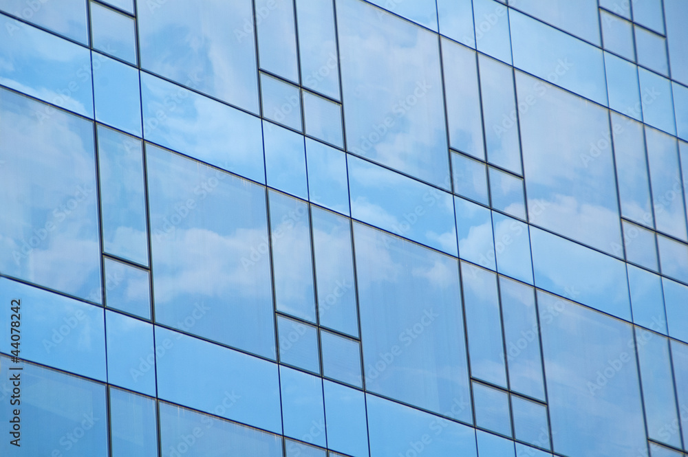 Blue sky and clouds reflecting on a building with mirrored glass Blue sky and clouds reflecting on a building with mirrored glass