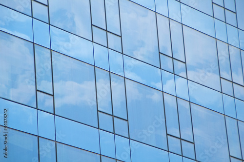 Blue sky and clouds reflecting on a building with mirrored glass