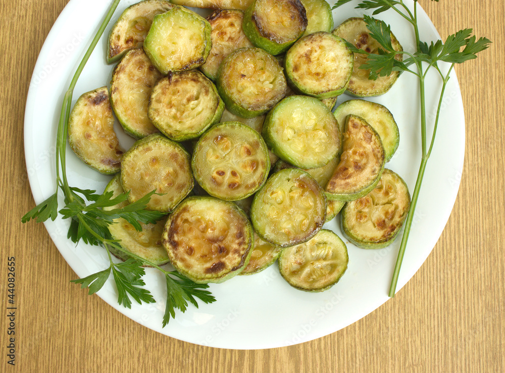 Fried zucchini slices on a white plate close up Fried zucchini slices on a white plate close up
